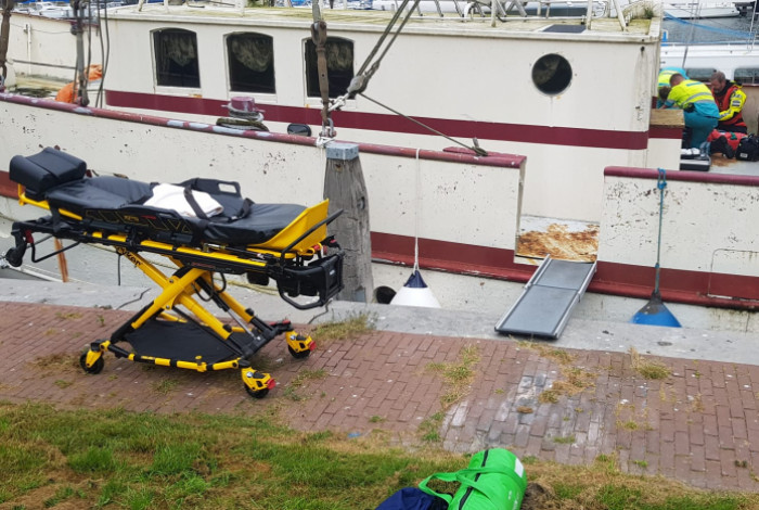 KNRM Medemblik assisteert ambulancepersoneel bij persoon van boord schip halen