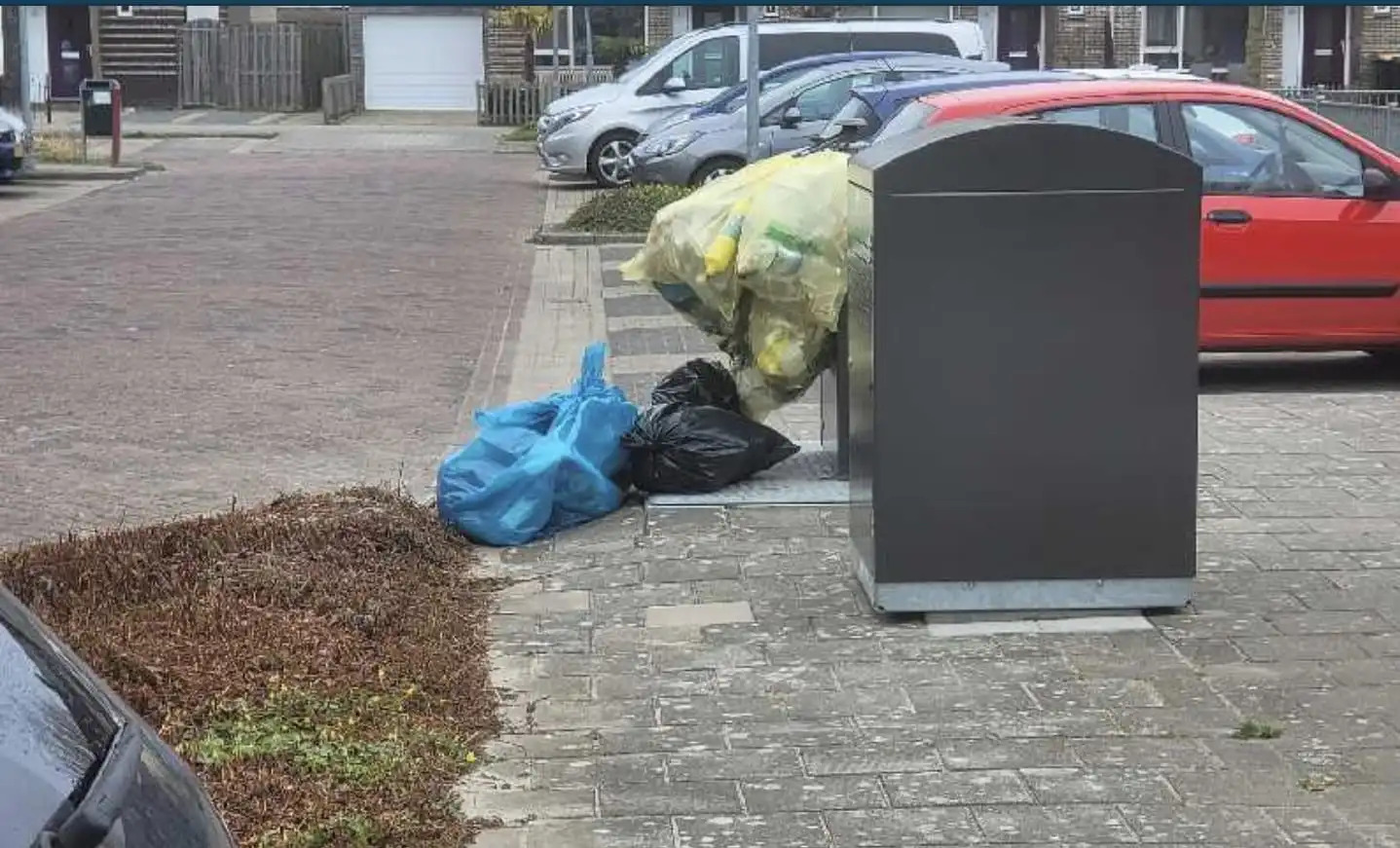 Op de foto: Afvalzakken liggen op de grond en worden niet meegenomen door HVC