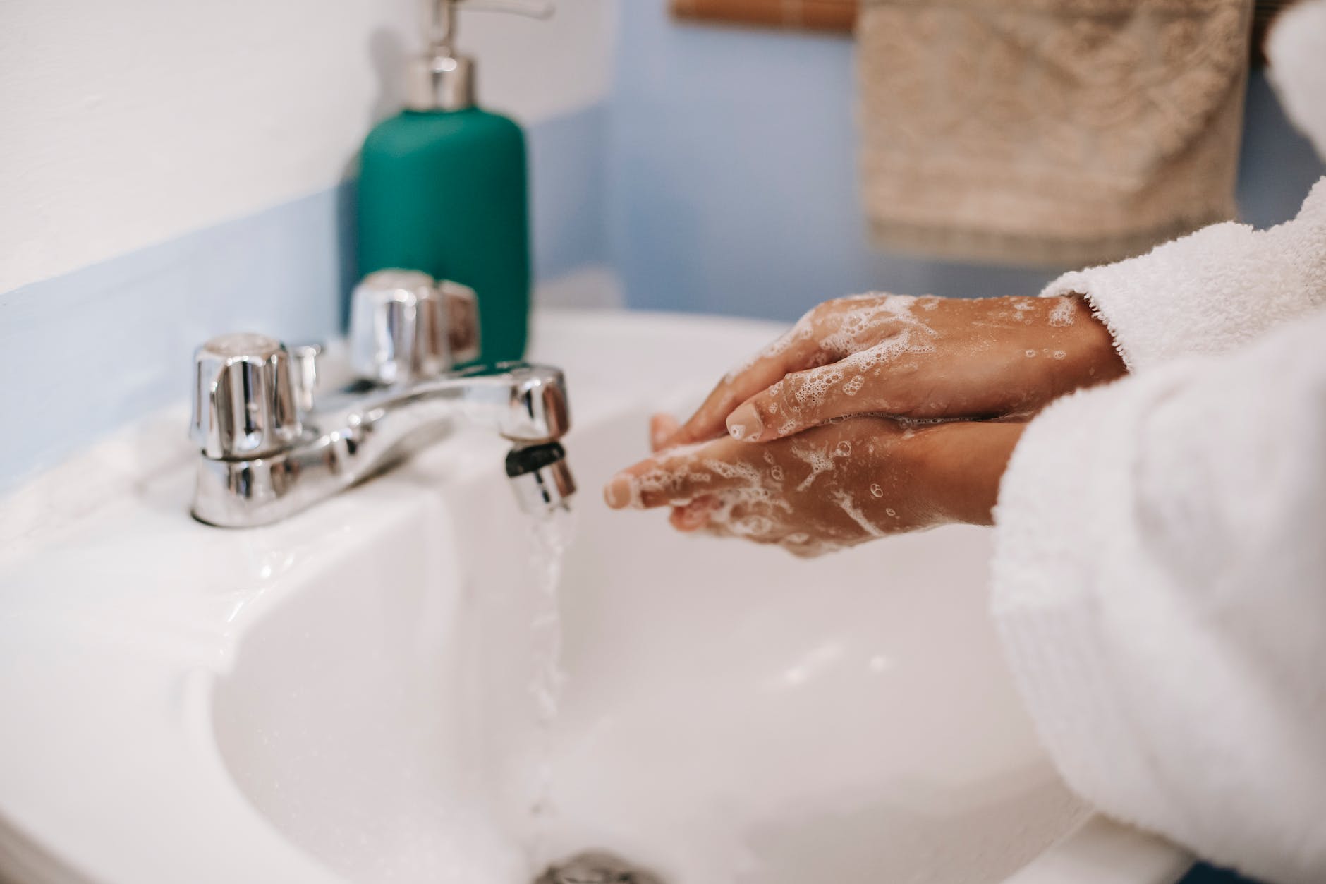 black woman washing hands in bathroom