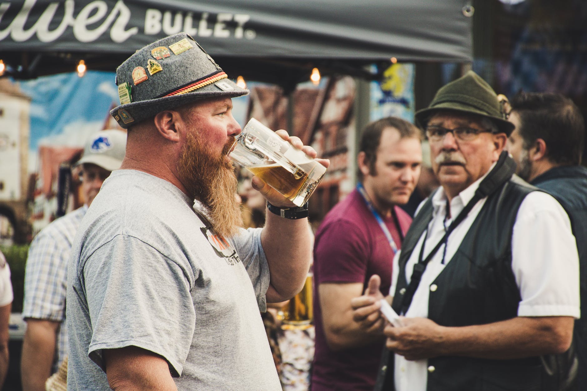 man drinking from a beer pint